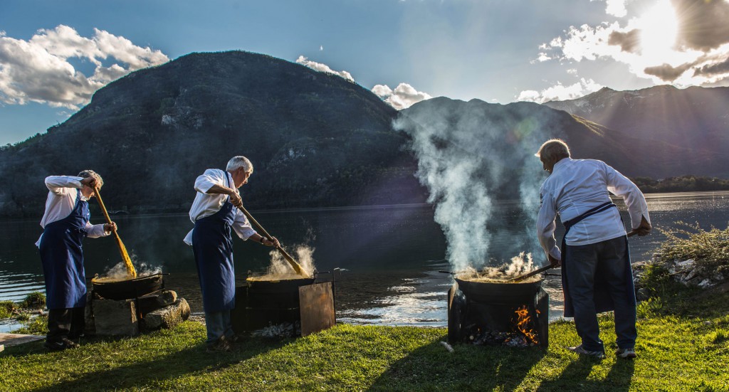 Men cooking outside wiht Italian lake background