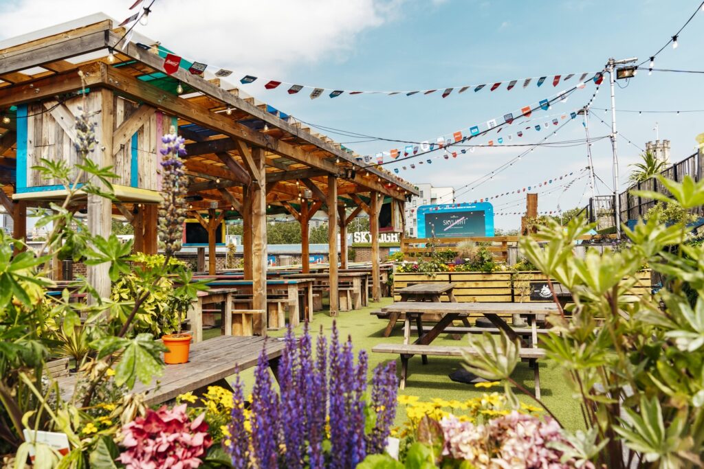 Sun-lit roof deck with picnic tables set up for a summer party