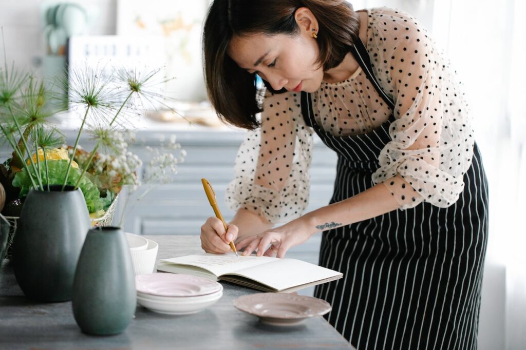 Woman writing in cookbook